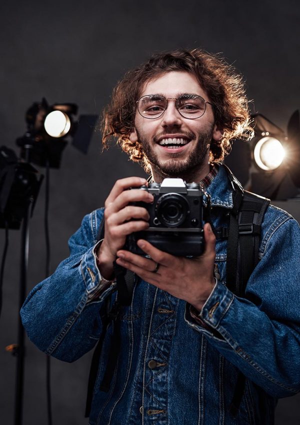 young-photographer-holds-a-camera-studio-portrait-resize.jpg
